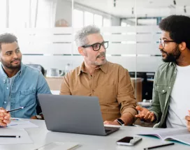 Team of engaged employees collaborating in a modern office, showing how culture helps retain talent