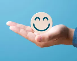 A hand holding a smiling face