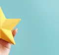 Image shows a hand holding a foam, yellow star.