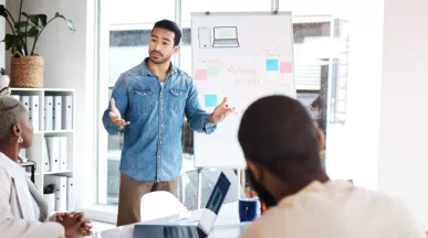 An employee presenting in front of three coworkers