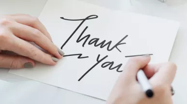 Person writing a thank you note