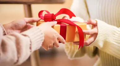 A person handing a gift to another person