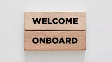Image shows two wooden blocks stacked on top of each other that say "Welcome Onboard"