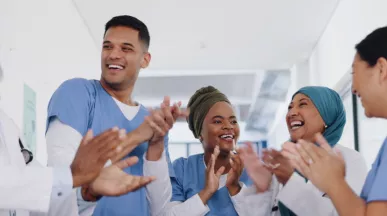 Three nurses and doctors celebrating by clapping their hands
