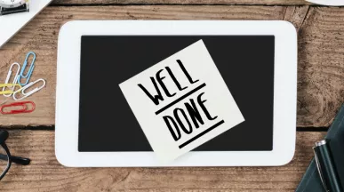 Image shows a sticky note on a desk that says "Well Done"
