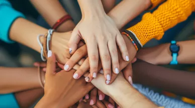 Shows a bunch of hands stacked together