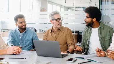 Team of engaged employees collaborating in a modern office, showing how culture helps retain talent