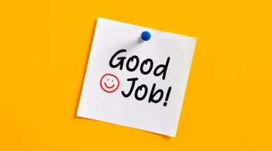 Peer-to-peer recognition message that says "Good Job!" on a sticky note